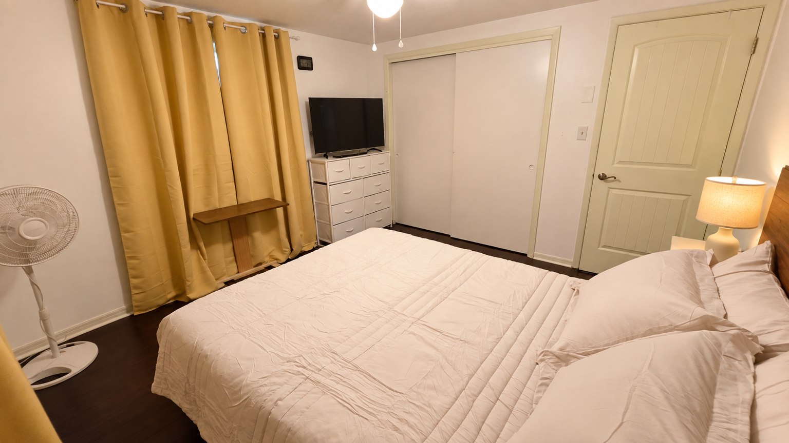 Bedroom view showing the TV, dresser, and closet